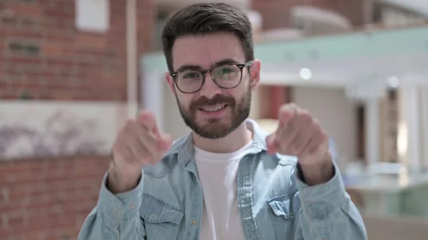 Jeune homme à lunettes pointant doigt à la caméra — Photo