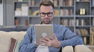 Tablet kullanan hırslı genç adamın portresi.