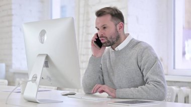 Yaratıcı Adam İş yerinde Akıllı Telefonla Konuşuyor