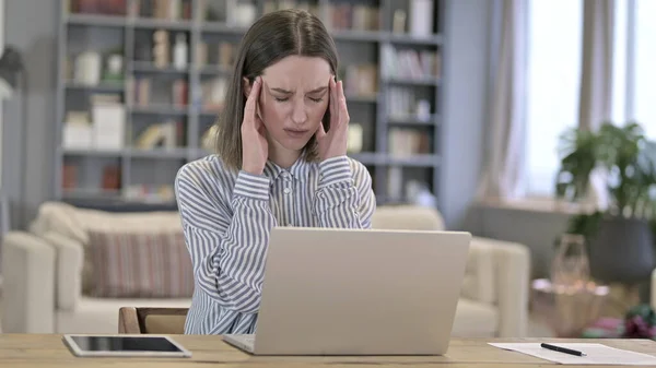 Junge Frau arbeitet am Laptop und hat Kopfschmerzen im Büro — Stockfoto