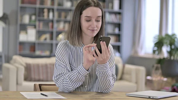 Junge Frau nutzt Smartphone im Loft-Büro — Stockfoto