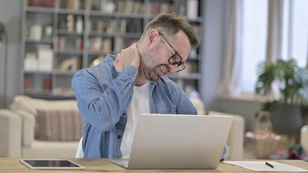 Young Man having Neck Pain in Loft Office