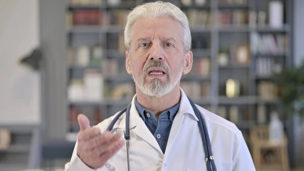 Porträt eines seriösen alten Arztes beim Videochat — Stockfoto