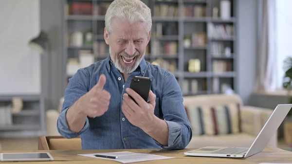 Älterer Mann feiert Erfolg auf dem Smartphone — Stockfoto