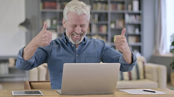 Амбициозный пожилой человек празднует успех на ноутбуке — стоковое фото
