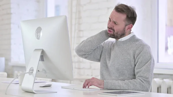 Uomo creativo con dolore al collo al lavoro — Foto Stock