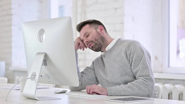 Müder kreativer Mann schläft während er am Computer arbeitet — Stockfoto