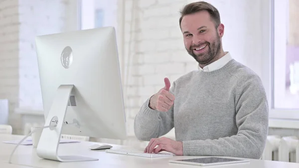 Pollici alzati dall'uomo creativo al lavoro — Foto Stock