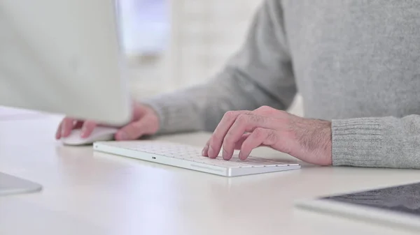 Mężczyzna wpisujący na klawiaturze, pracujący na komputerze — Zdjęcie stockowe