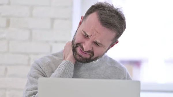 Nahaufnahme eines jungen Mannes mit Nackenschmerzen bei der Arbeit — Stockfoto