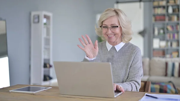 Vieille femme faisant chat vidéo sur ordinateur portable dans le bureau moderne — Photo