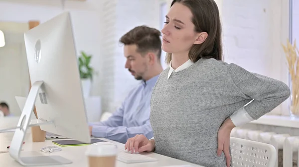 Femme créative fatiguée ayant mal au dos dans le bureau moderne — Photo
