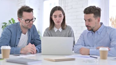 Dizüstü bilgisayarda birlikte çalışan üç yaratıcı profesyonel