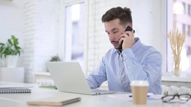 Yaratıcı Adam İş yerinde Akıllı Telefonla Konuşuyor