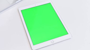 Top View of Tablet with Chroma Key Screen on White Table
