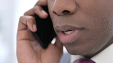 Akıllı telefondan konuşan kızgın Afrikalı adamın yüzü