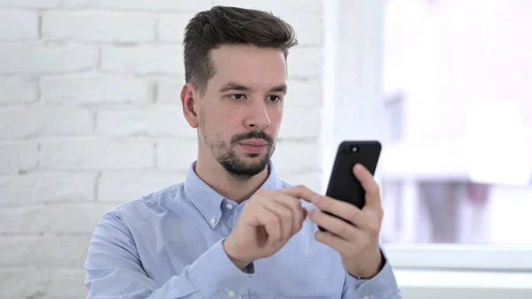 Hombre joven usando la aplicación Smartphone —  Fotos de Stock