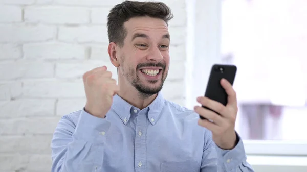 Giovane uomo che celebra il successo su Smartphone — Foto Stock