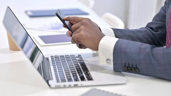 Nahaufnahme eines professionellen Afrikaners mit Smartphone im Büro — Stockfoto