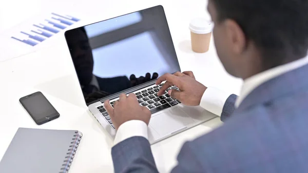 Nahaufnahme der Hände eines afrikanischen Geschäftsmannes, der im Büro am Laptop arbeitet — Stockfoto