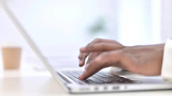 Primo piano di uomo africano Mani Dattilografia sul computer portatile — Foto Stock