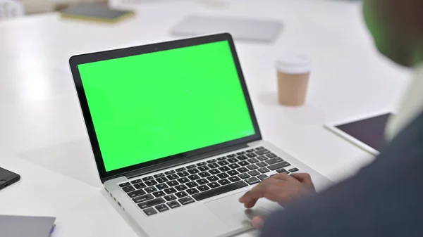 Afrikaner arbeitet am Laptop mit grünem Chroma-Schlüsselbildschirm — Stockfoto