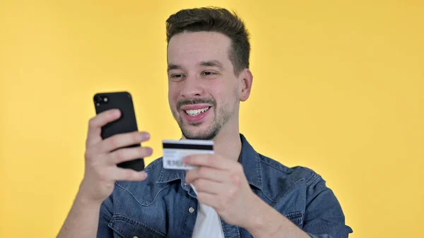 Hombre joven Compras en línea en Smartphone por Hombre joven, Fondo amarillo —  Fotos de Stock
