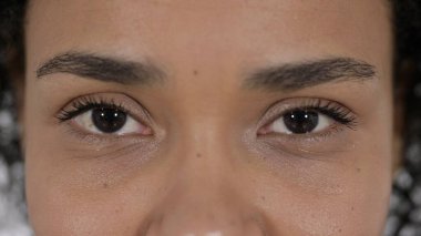 Genç bayanın yanıp sönen gözleri kameraya bakıyor.