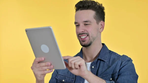 Homem jovem usando Tablet, fundo amarelo — Fotografia de Stock