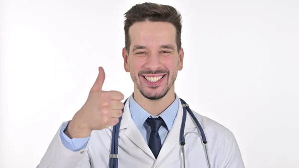 Joven macho doctor mostrando pulgares arriba, fondo blanco — Foto de Stock