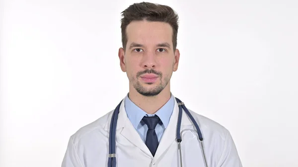 Junger männlicher Arzt blickt in die Kamera, weißer Hintergrund — Stockfoto