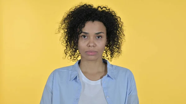 Mujer africana casual mirando a la cámara, fondo amarillo — Foto de Stock