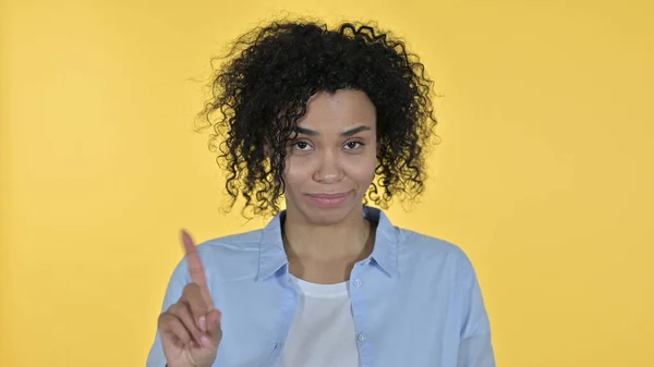 Atractiva mujer africana diciendo no por dedo, fondo amarillo —  Fotos de Stock