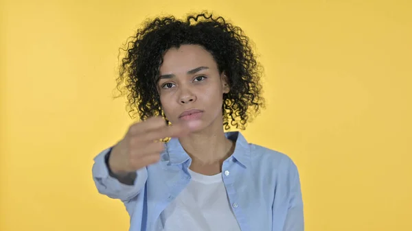 Rude mulher africana mostrando dedo médio, fundo amarelo — Fotografia de Stock