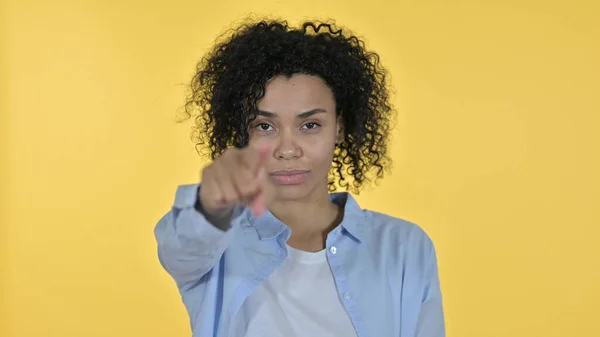 Vacker afrikansk kvinna pekande på kameran, gul bakgrund — Stockfoto