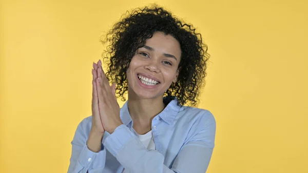 Mujer africana feliz aplaudiendo, fondo amarillo — Foto de Stock