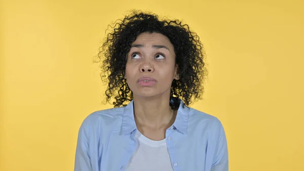 Rädd afrikansk kvinna känner sig rädd, gul bakgrund — Stockfoto