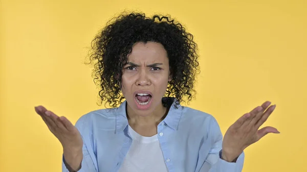 Mujer africana decepcionada reaccionando al fracaso, fondo amarillo — Foto de Stock