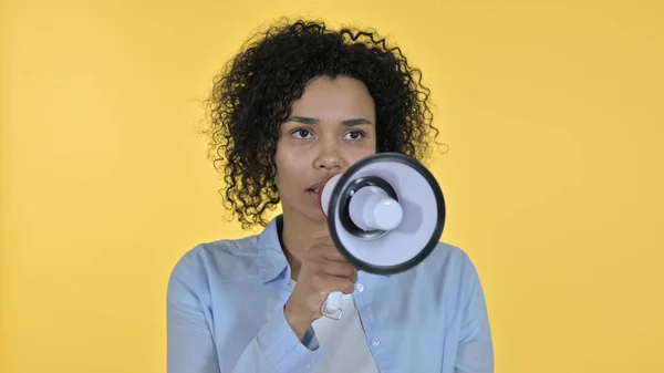 Mulher Africana fazendo anúncio em alto-falante, fundo amarelo — Fotografia de Stock