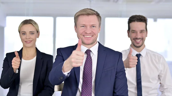 Portret van een vrolijk zakenteam met duimen omhoog — Stockfoto
