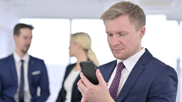 Focused Businessman Korzystanie ze smartfona w biurze — Zdjęcie stockowe