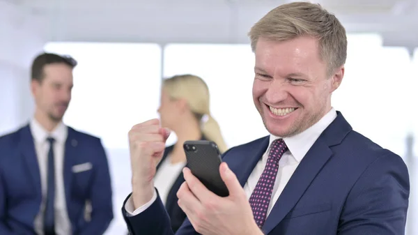 Empresário alegre comemorando o sucesso no Smartphone — Fotografia de Stock