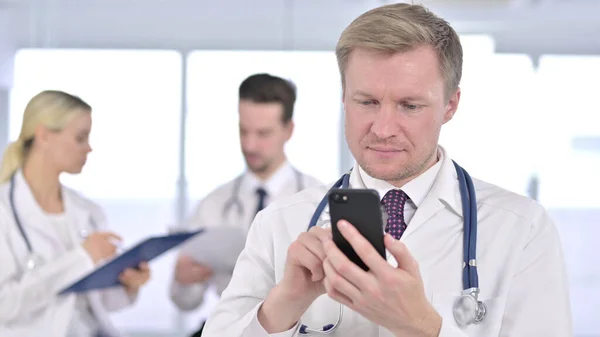 Ofiste Smartphone kullanan Ciddi Erkek Doktor — Stok fotoğraf