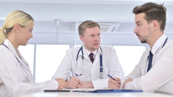 Kıdemli Erkek Doktor Klinikte Genç Doktorlarla Konuşuyor — Stok fotoğraf