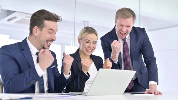 Gente alegre de negocios celebrando el éxito en el ordenador portátil —  Fotos de Stock