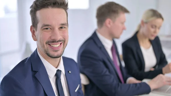 Portrét veselého podnikatele usmívajícího se na kameru v kanceláři — Stock fotografie