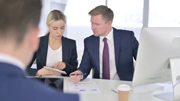 Profesionales enfocados discutiendo documentos y trabajando en tabletas —  Fotos de Stock