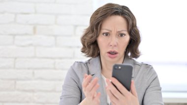 Merak eden yaşlı kadın Smartphone 'da şok oldu.
