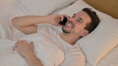 Yatakta Akıllı Telefonla Konuşan Mutlu Genç Adam