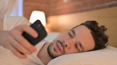 Genç Adam Yatakta Akıllı Telefon Kullanıyor